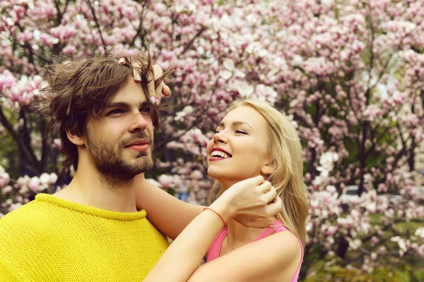 Hermosa pareja romántica bajo el árbol de magnolia floreciente en el día de primavera —  Fotos de Stock