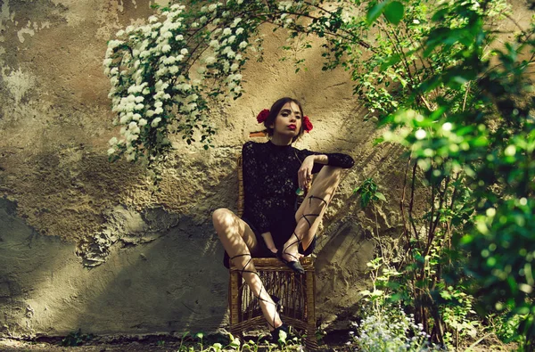 Жінка з квіткою в роті сидить на стільці — стокове фото