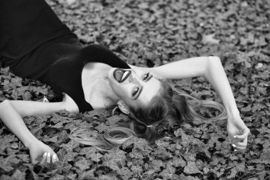 Yeşil üzüm asma yapraklarını yalan moda elbise kırmızı dudaklar ile güzel genç kadın