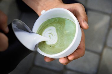 mükemmel sabah yeşil kahve ile. Barista Japon çay içecek süt dökün. Matcha sütlü çay töreni, pour süt. kafe veya kahve dükkanı ve içme rahatlayın. Macera devam etmek için taze çay