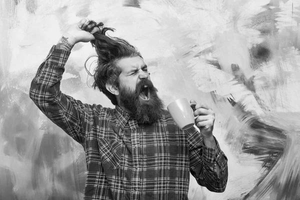Плачущий бородатый мужчина тянет стильные волосы с голубой чашкой — стоковое фото