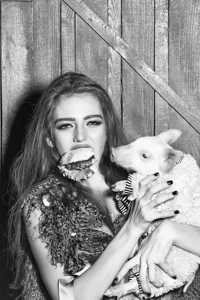 Девушка с бургером и свиньей — стоковое фото