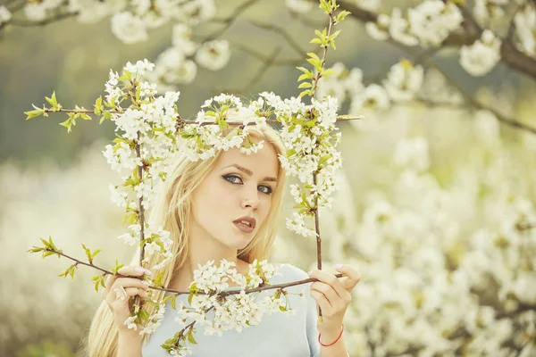 Mulher adorável segurando quadro de flores brancas, florescentes — Fotografia de Stock