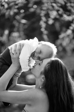 Mutlu sevimli bebek çocuk, küçük, küçük, oğlu ve güzel anne, kadın, eğleniyor, uzun saçlı, gülümseyen güneşli yaz doğa doğal zemin üzerine açık havada. Anneler günü, aile sevgisi