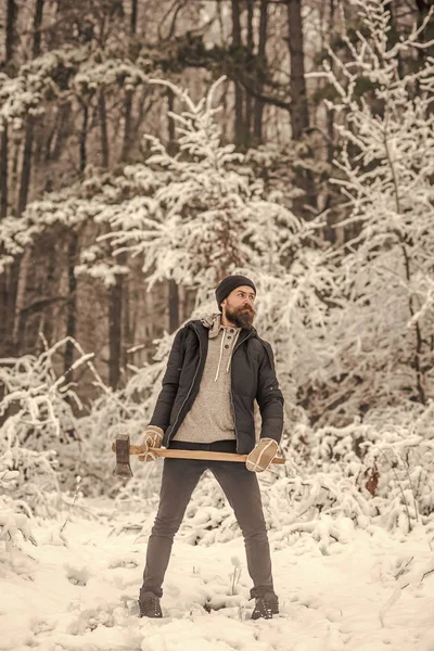 Homem barbudo com machado na floresta nevada . — Fotografia de Stock