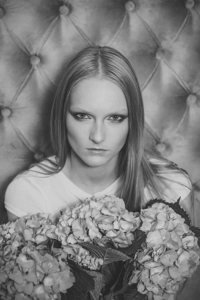 Mujer con flores de hortensias en pared gris —  Fotos de Stock