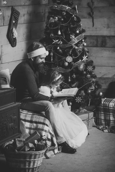Weihnachtsglückliches Kind und Vater lesen Buch. — Stockfoto