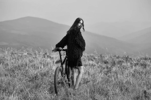 Chica con bicicleta en la montaña — Foto de Stock