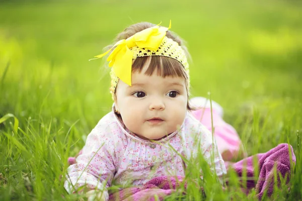 Niedliches kleines Mädchen auf grünem Gras — Stockfoto