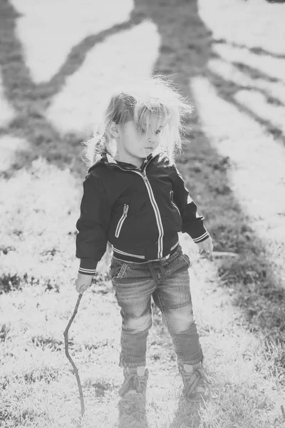 Niño niño en chaqueta azul y jeans jugar con palo —  Fotos de Stock