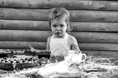 Tatlı küçük çocuk böğürtlen yiyor.