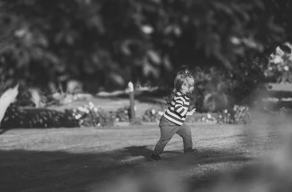 Chico correr en verde hierba en verano jardín — Foto de Stock