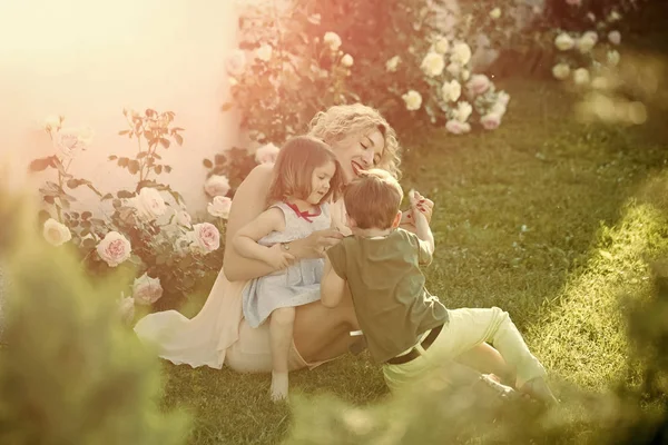 在夏日花园里和女儿和儿子玩耍的母亲 — 图库照片