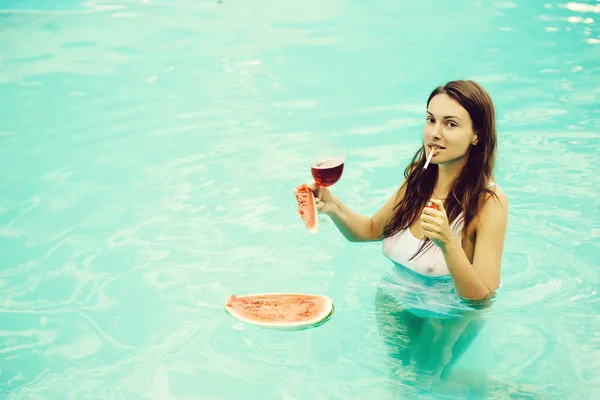 Meisje rokend met watermeloen en wijn in zwembad — Stockfoto