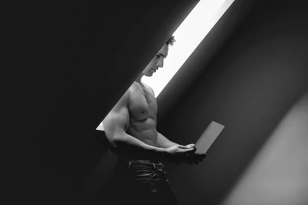 Homem muscular com laptop — Fotografia de Stock