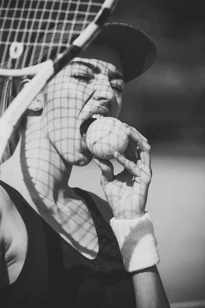 Žena kousnout tenisový míč venkovní, aktivita — Stock fotografie