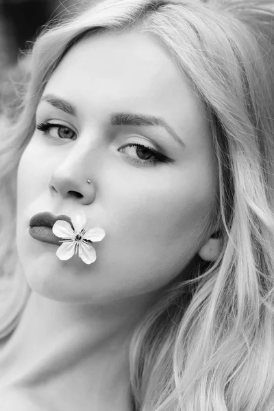 Jovem menina segura na boca uma flor de cereja branca — Fotografia de Stock