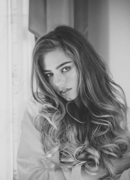 Girl with mysterious face and long curly hair in bathrobe. — Stock Photo, Image