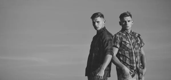 Gemelos hombres en camisas al aire libre en el cielo azul soleado — Foto de Stock