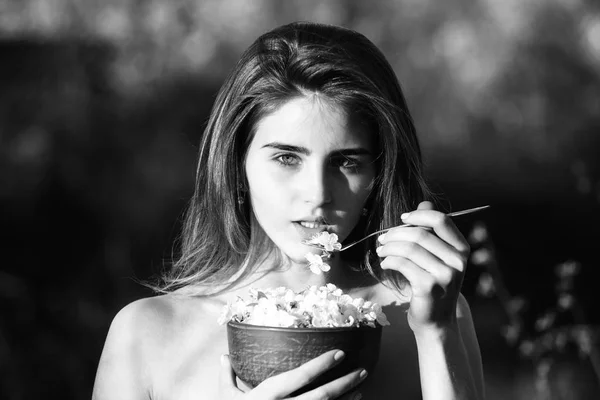 Chica comiendo blanco, pétalos de flor de cerezo — Foto de Stock