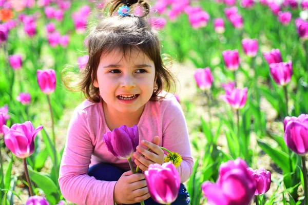 Bela primavera. Menina na primavera ensolarada. Moda menina de verão. Feliz infância. Cuidados com a pele. alergia às flores. Tulipas da Primavera. previsão meteorológica. Criança pequena. Beleza natural. Dia das crianças — Fotografia de Stock