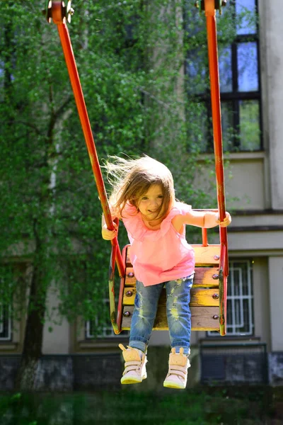 Parque infantil en el parque. Un niño pequeño jugando en verano. infancia daydream .teen libertad. Feliz niña riendo en swing. Niña romántica en el columpio, dulces sueños. ¡Vaya! Momentos felices — Foto de Stock