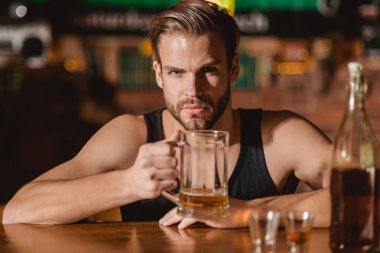 O bira büyük bir hayranıdır. Alkollü içecek addicting. Bira bardağı ile alkol bağımlısı. Adam alkol barda. Yakışıklı adam içki bira bar sayacı. Bira restoran. Alkol bağımlılığı ve kötü alışkanlık