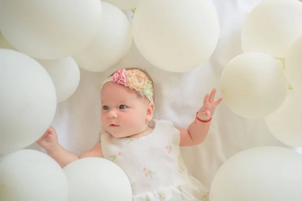 Like on catwalk. Sweet little baby. New life and birth. Small girl. Happy birthday. Family. Child care. Childrens day. Portrait of happy little child in white balloons. Childhood happiness