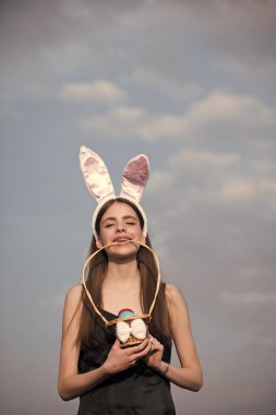 Tavşan kulakları ve mavi gökyüzü üzerinde yumurta Paskalya kızla
