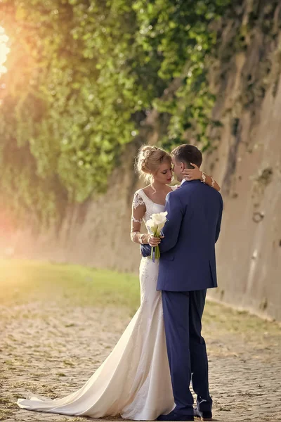 Красивая свадебная пара у каменной стены — стоковое фото