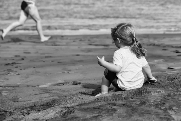Lindo bebé niño se sienta en la arena en la playa de arena —  Fotos de Stock