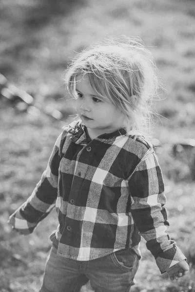 Bambino con i capelli biondi in camicia blu scozzese, jeans — Foto Stock