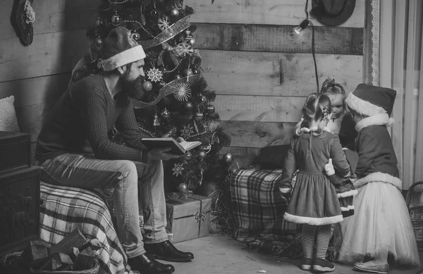 Santa claus kid and bearded man at Christmas tree.