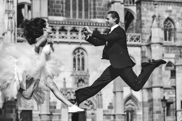 Wedding happy couple jumping near castle — Stock Photo, Image