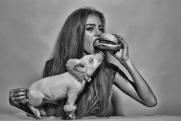 Girl eating burger with pig