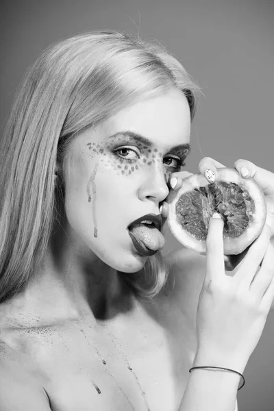 Грейпфрут в руках женщины с креативным модным макияжем, витамином — стоковое фото