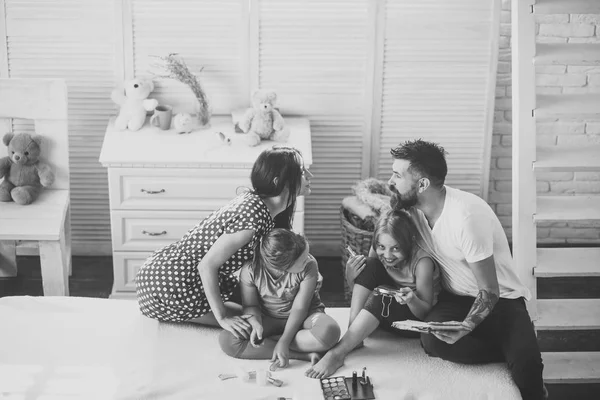 Madre, padre e hijas lindas en acogedor apartamento —  Fotos de Stock