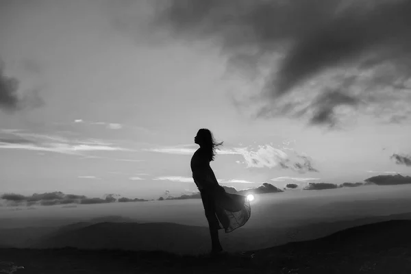 Mujer al atardecer o al amanecer en las montañas — Foto de Stock