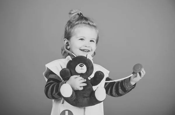 Lycklig pojke i läkare enhetliga undersöka leksak pet med stetoskop — Stockfoto
