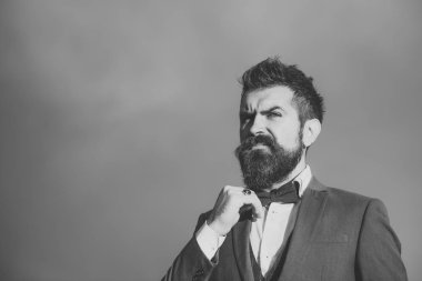 Düşünceli yüz Klasik takım elbiseli adamla papyon dokunur.