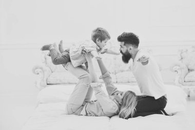 Ailesiyle mutlu yüzler, evlat, uçak gibi çal dikkat. Annem ve babam sevimli oğlu ile oynamak. Genç aile zaman harcamak birlikte yatağa, lüks iç arka plan. Mutlu aile kavramı.