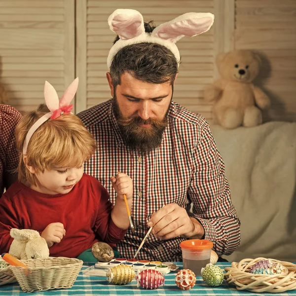 Father and son paint handmade egg.