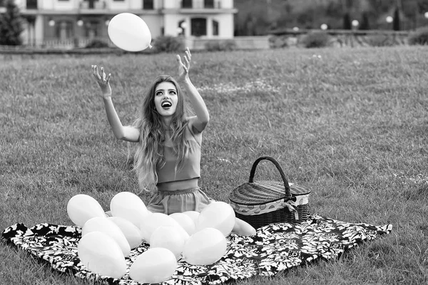 Vrouw op picknick met ballonnen — Stockfoto