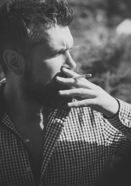 sağlıksız yaşam tarzı ve bağımlılığı ile adamın kötü alışkanlık. adam Sigara İçilmeyen. Genç hipster sakal ve bıyık üzerinde ciddi bir yüz duman sigara açık sakallı. Kuaför ve berber dükkanı