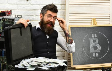 Zengin ve akıllı. Sunucu odasında iş adamı. Sakallı adam nakit para ile. Sakallı hippi bitcoin sembol ve dolar ile. Kripto para birimi için kağıt para. Bitcoin iş için