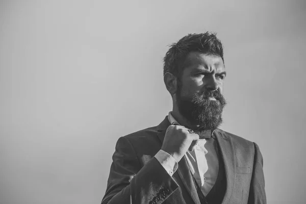 Guy with thoughtful face in classic suit touches bow tie. — Stock Photo, Image