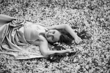 Yaprakları yeşil çimenlerin üzerinde küçük kız