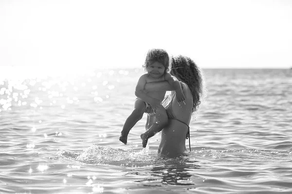 Mujer en bikini con niño — Foto de Stock