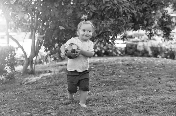 Fröhliche süße Baby-Junge spielt mit Ball auf grünem Gras — Stockfoto