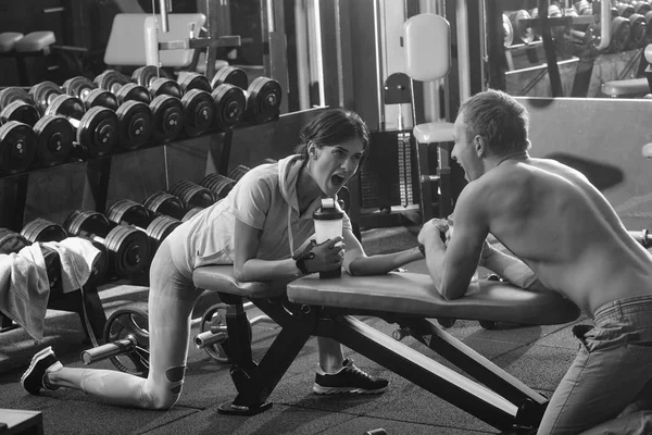 Armwrestling muskulöse Mann und Mädchen in der Turnhalle — Stockfoto